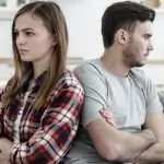 hombre y mujer de espaldas uno del otro con cara de preocupación