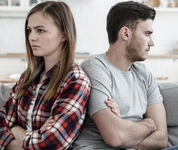 hombre y mujer de espaldas uno del otro con cara de preocupación