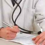 medico firmando una hoja de diagnostico medico