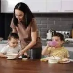 madre sirviendo alimentos a sus dos hijos en una mesa