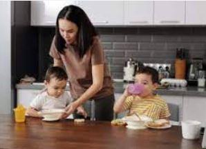 madre sirviendo alimentos a sus dos hijos en una mesa