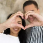 imagen de hombre y mujer, cada uno con su mano dibujando entre los 2 un corazón